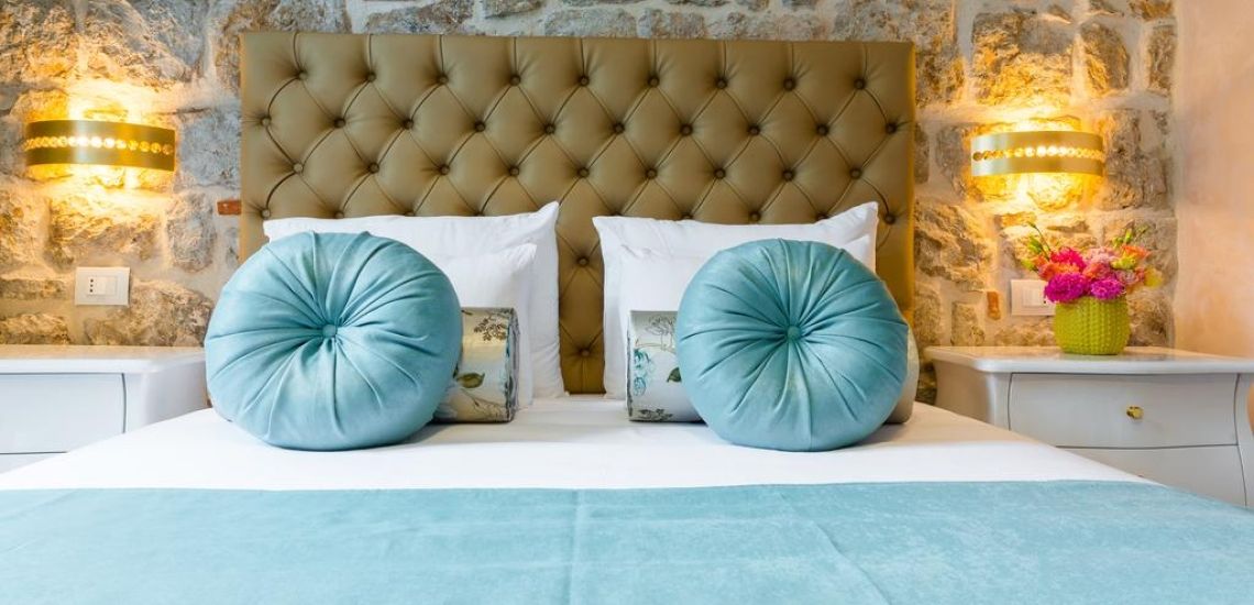 Mooi opgemaakt bed met blauwe kussens